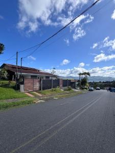 eine leere Straße mit einem Haus am Straßenrand in der Unterkunft Morpho Glamping in Nuevo Arenal