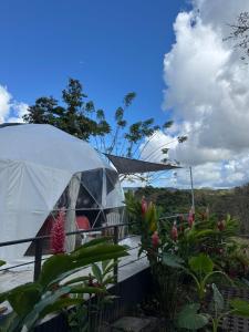 ein weißes Zelt mit Tisch, Stühlen und Blumen in der Unterkunft Morpho Glamping in Nuevo Arenal