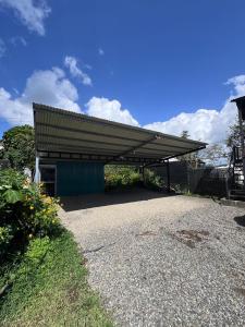 ein Gebäude mit Metalldach auf einer Kiesauffahrt in der Unterkunft Morpho Glamping in Nuevo Arenal + 9 Fotos