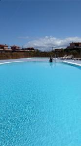 a large pool of blue water with a person sitting in it at Mi Casa in Majanicho