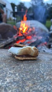 a sandwich sitting on a table next to a fire at The Summit Suite | Walk to Rangeley Lake • ATV & Sled Access in Rangeley