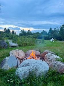 a fire pit in a field with large rocks at The Summit Suite | Walk to Rangeley Lake • ATV & Sled Access in Rangeley