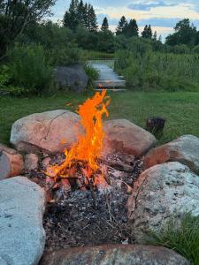 a fire pit with rocks in a yard at The Summit Suite | Walk to Rangeley Lake • ATV & Sled Access in Rangeley