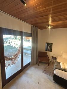 a bedroom with a bed and a sliding glass door at Villaflor Pousada in Vale do Capao