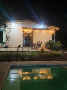a house with a swimming pool at night at Cabañas Mantas in Tárcoles +35 photos