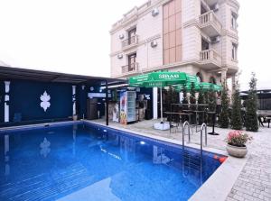 a swimming pool in front of a building at Caspian Seaside Hotel in Sumqayıt