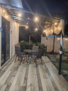 a patio with a table and chairs and an umbrella at Cabañas Mantas in Tárcoles