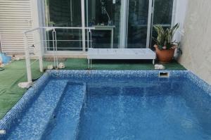 a blue swimming pool in front of a house at Trade winds International in Progreso