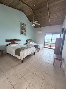 a bedroom with two beds and a ceiling fan at Taitza in San José