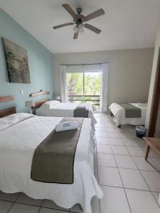 a bedroom with two beds and a ceiling fan at Taitza in San José