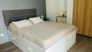 a bedroom with a large bed with a gray headboard at Villa Pérola Pestana in Lourinhã