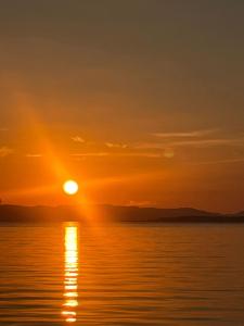 an orange sunset over the water with the sun setting at Taitza in San José