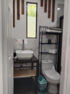 a bathroom with a sink and a toilet at Cabañas Mantas in Tárcoles