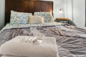 a bed with two pairs of slippers on it at Borealis Barnhouse - Slumber 7 in Anchorage