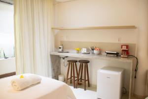 a room with a bed and a kitchen with a counter at Suites Amma Noronha in Fernando de Noronha +112 photos