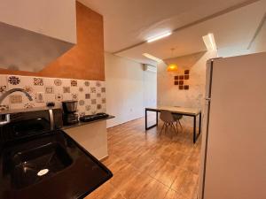 a kitchen with a table and a counter top at Loft Moderno I in Mossoró