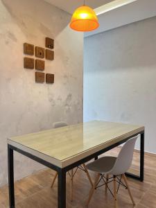 a dining room table with two chairs and a light fixture at Loft Moderno I in Mossoró