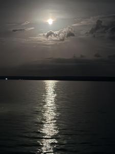 a sunset over a body of water with the sun at Taitza in San José