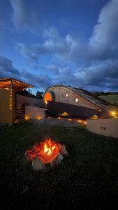 a fire in the grass in front of a building at Glampings Magic Bungalow in Villa de Leyva