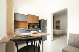 a kitchen with a table with chairs and a refrigerator at La Palma Experience in Panama City