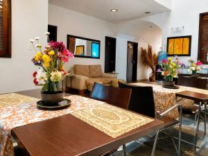 a room with tables and chairs with flowers on them at hostal cf bed y breakfast in Cali