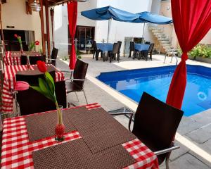 a patio with tables and chairs next to a swimming pool at hostal cf bed y breakfast in Cali +57 photos