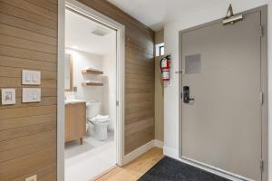 a bathroom with a door leading to a toilet at Powder's Edge by Whiski Jack in Whistler +29 photos
