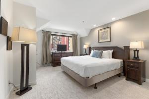 a bedroom with a large bed and a television at Powder's Edge by Whiski Jack in Whistler