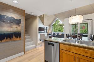 a kitchen with a sink and a living room at Powder's Edge by Whiski Jack in Whistler