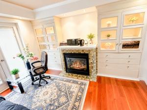 a living room with a fireplace and a chair at Your own home in Toronto