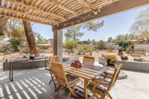 a wooden table and chairs on a patio at Cowboy Tubs, Zen Labyinth, Views, Quiet Serenity in Joshua Tree