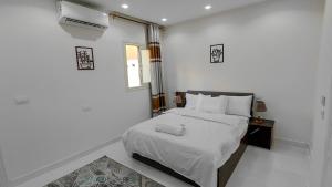 a white bedroom with a bed and a window at 325 · 2BR Townhouse 2 Bath TV in Sheikh Zayed