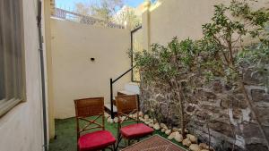 two chairs with red cushions sitting next to a wall at 325 · 2BR Townhouse 2 Bath TV in Sheikh Zayed
