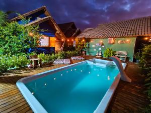 a pool in the backyard of a house at night at Chalés Cabocla da Lua in Caraíva