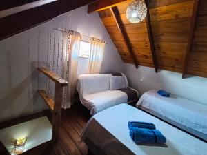 a small room with two beds and a chair at Chalés Cabocla da Lua in Caraíva +34 photos