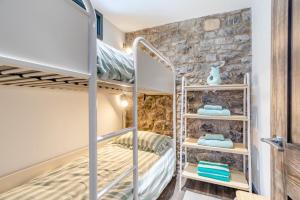 a bedroom with bunk beds in a room with a stone wall at 2 Bed in Tenby oc-b41400 in Tenby