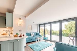 a kitchen and living room with a blue couch at 2 Bed in Tenby oc-b41400 in Tenby