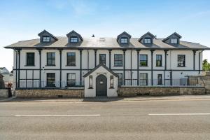 a large white and black house on the side of the street at 2 Bed in Tenby oc-b41400 in Tenby