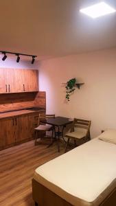 a room with a bed and a table and chairs at Korja Apartments Mavrovo in Mavrovo