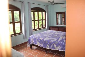 a bedroom with a bed in a room with windows at La Posada Pacifica in Puerto Vallarta