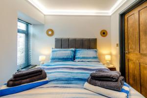 a bedroom with a large bed with towels on it at 2 Bed in Tenby oc-b41399 in Tenby