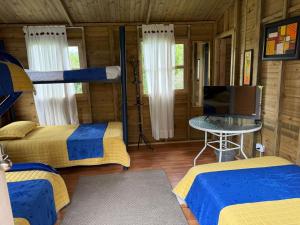 a room with two beds and a tv in a cabin at Cabañas Creation Garden - Espacio de Vida Saludable in San Francisco