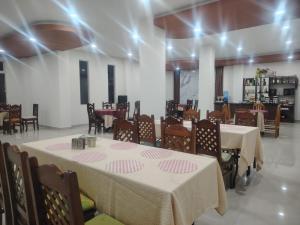 a dining room with two tables and chairs and a unintention at Hotel Central in Cochabamba