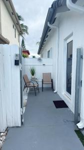 a patio with two chairs and a table next to a white fence at Private Miami Suite in Tamiami Airport