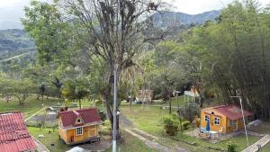 two small houses in a field with a tree at Cabañas Creation Garden - Espacio de Vida Saludable in San Francisco