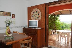 une salle à manger avec une table et une télévision sur une armoire dans l'établissement Appartamenti Spiaggia Bianca, à Golfo Aranci