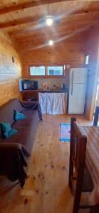 a living room with a couch in a wooden cabin at Refugio La Lechuza in San Rafael