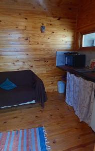 a room with a bed in a wooden cabin at Refugio La Lechuza in San Rafael