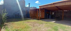 a house with a wooden structure in a yard at Refugio La Lechuza in San Rafael