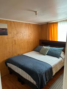 a bed in a small room with a window at Ruta Pata Austral in Puerto Varas